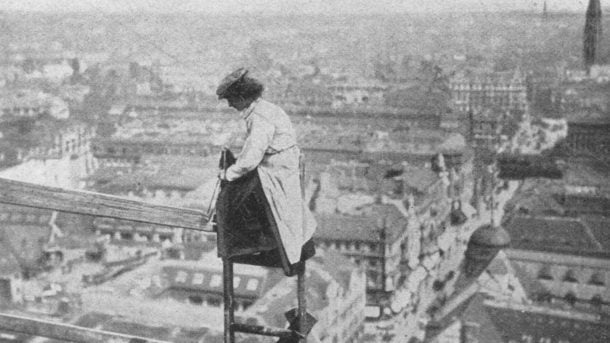 A female builder in Berlin shows off her daring to the press. She is repairing the roof of Berlin's City Hall in 1910. Illustrierte Frauenzeitung 38.